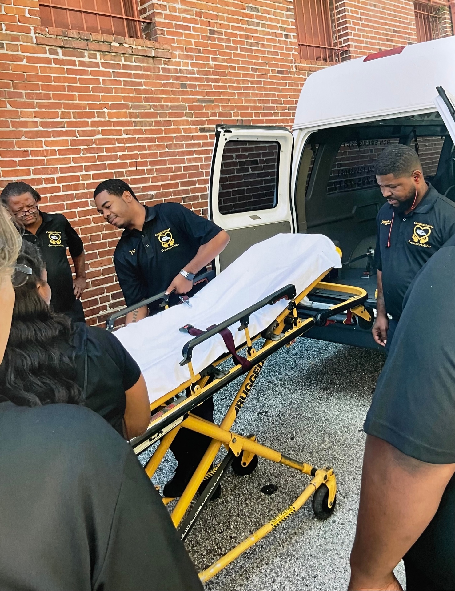 Team loading a stretcher into the transport van
